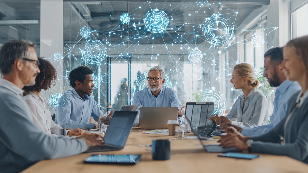 Diverse IT professionals collaborating around a conference table with laptops in a modern workspace, discussing web performance strategies.
