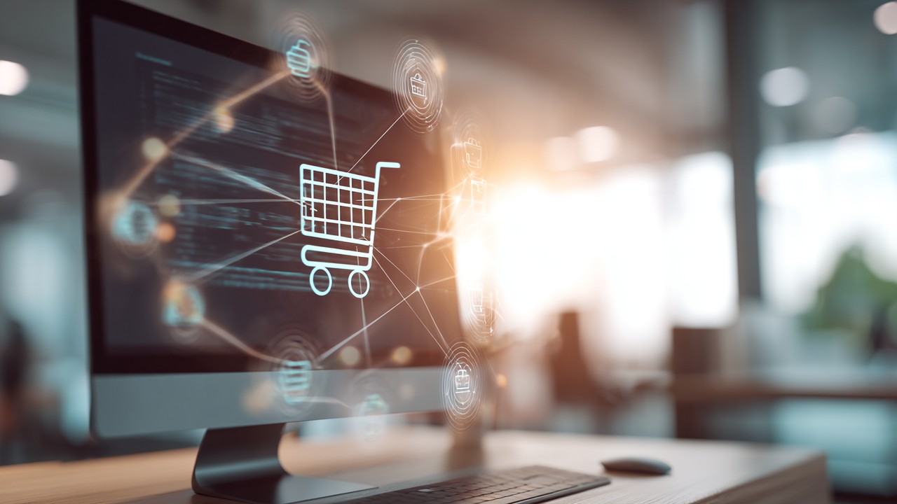 High-quality stock photo of a computer screen displaying an eCommerce shopping cart interface with digital data flow, in a modern office setting.
