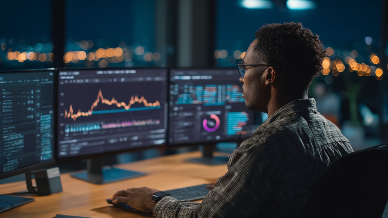 Web developer analyzing web performance metrics on multiple monitors with speed and latency graphs in a modern office setting.