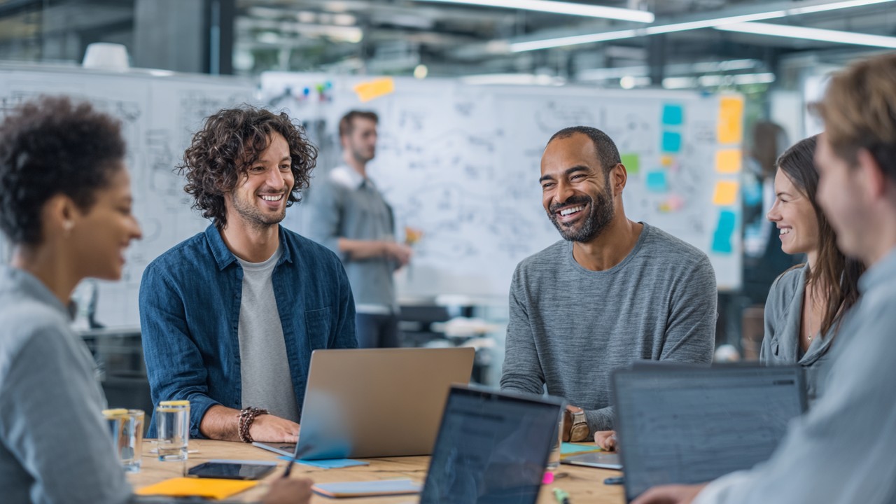 Diverse team van software engineers bespreekt serverless architectuur en optimalisaties in een moderne, lichte kantoorruimte met whiteboards en laptops.