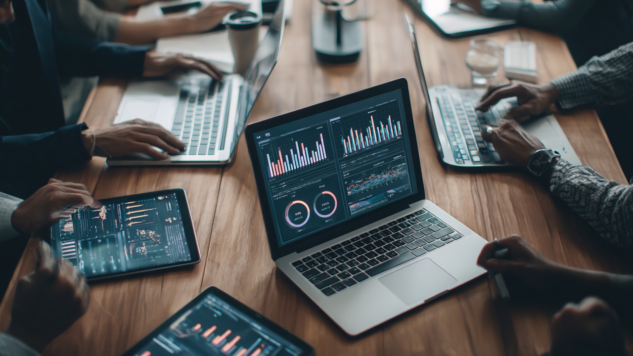 IT professionals collaborating around a conference table reviewing help desk ticket data visualizations and performance insights.